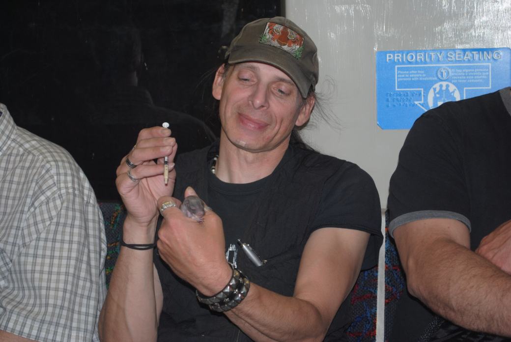 Man feeding baby squirrel on the T in Boston